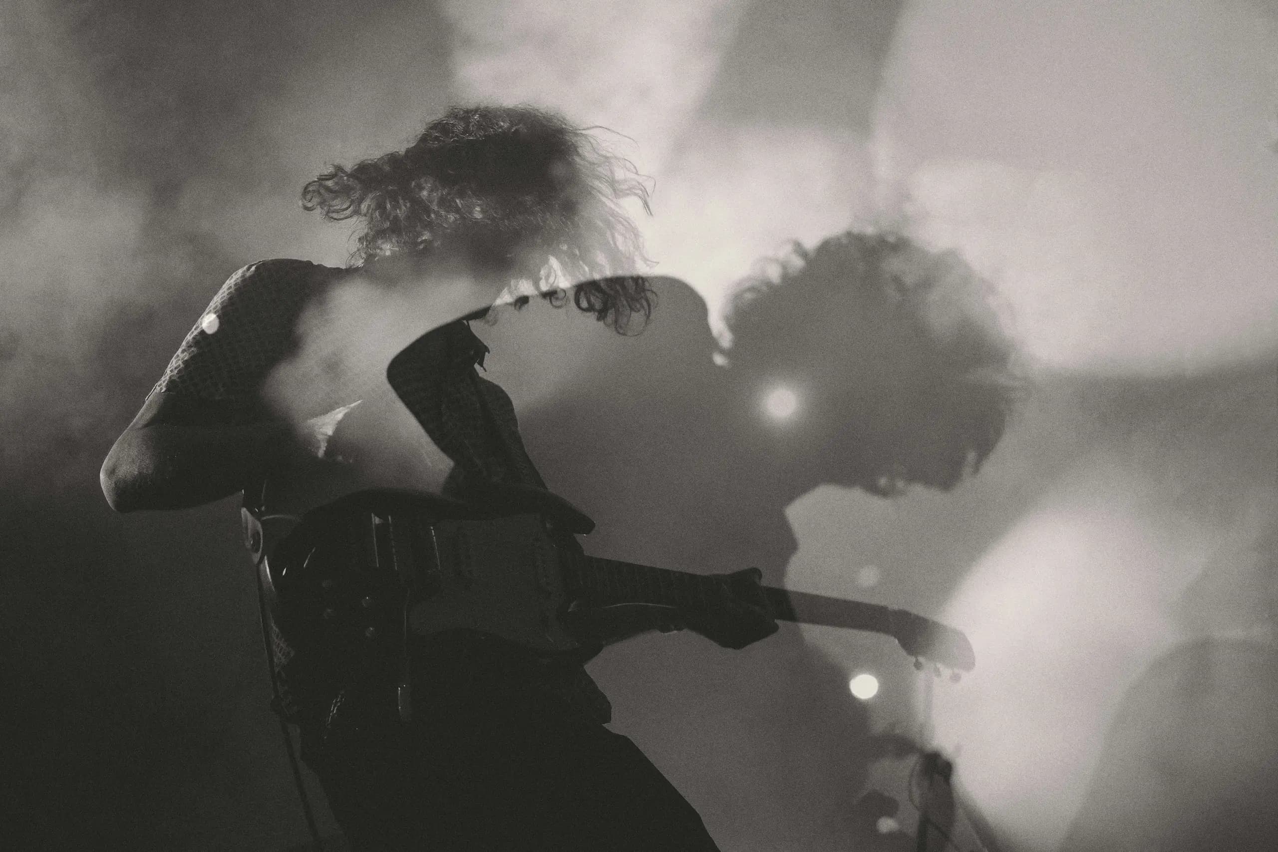 Artista tocando en directo entre luces y humo