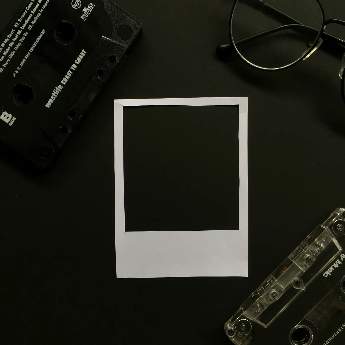 Casetes junto a un marco de fotografía todavía en blanco